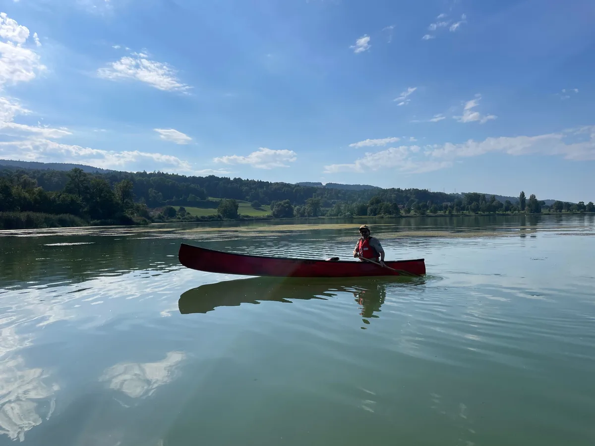 Rund eine Stunde ist er auf dem Greifensee unterwegs. Bild von einem Mann in einem roten Kanu auf dem See.